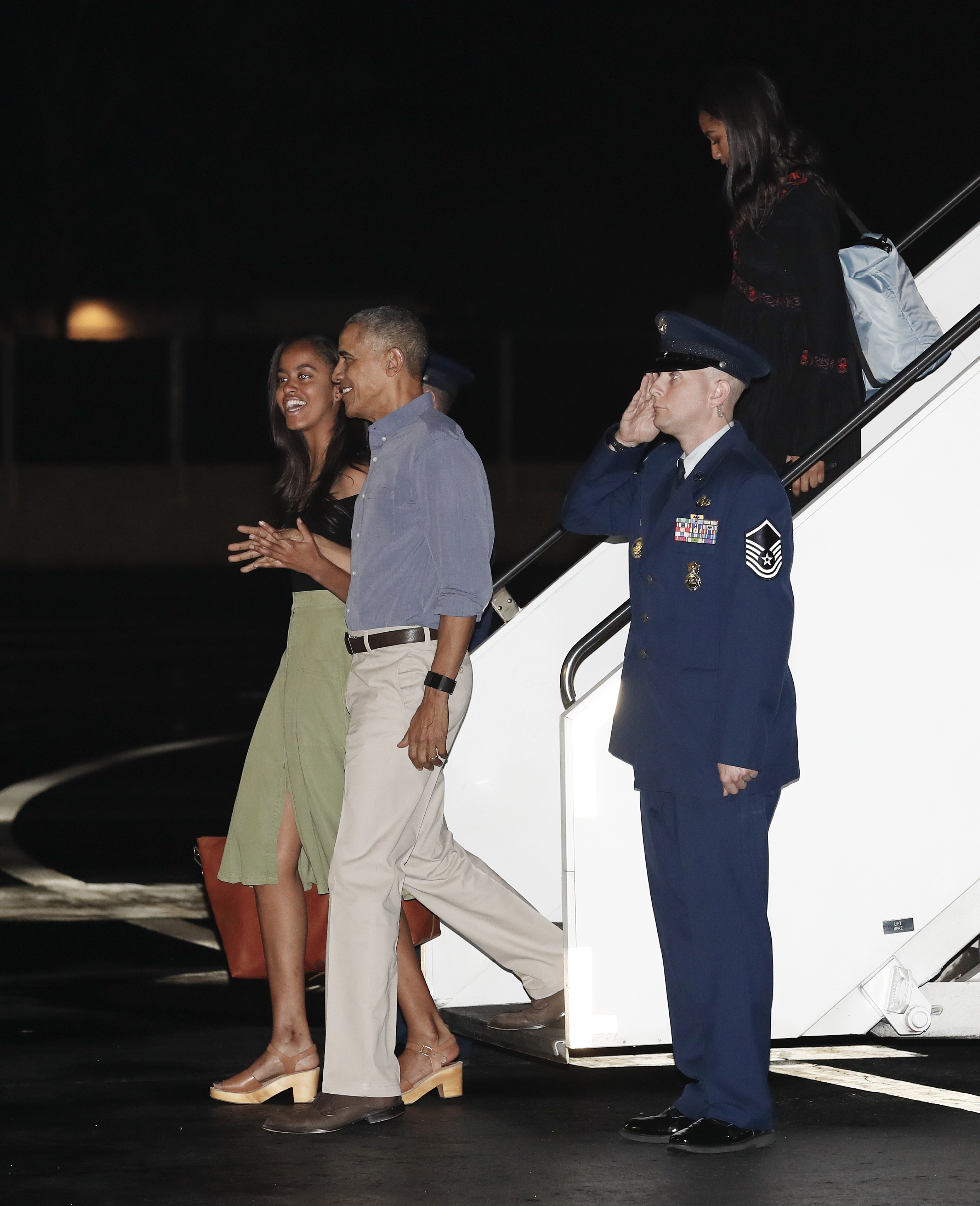 U.S. President Barack Obama and his daughters Malia, left, and Sasha arrive on Air Force One, Friday, Dec. 16, 2016, at Joint Base Pearl Harbor-Hickam, adjacent to Honolulu, Hawaii, for their annual family vacation on the island of Oahu. (AP Photo/Carolyn Kaster)