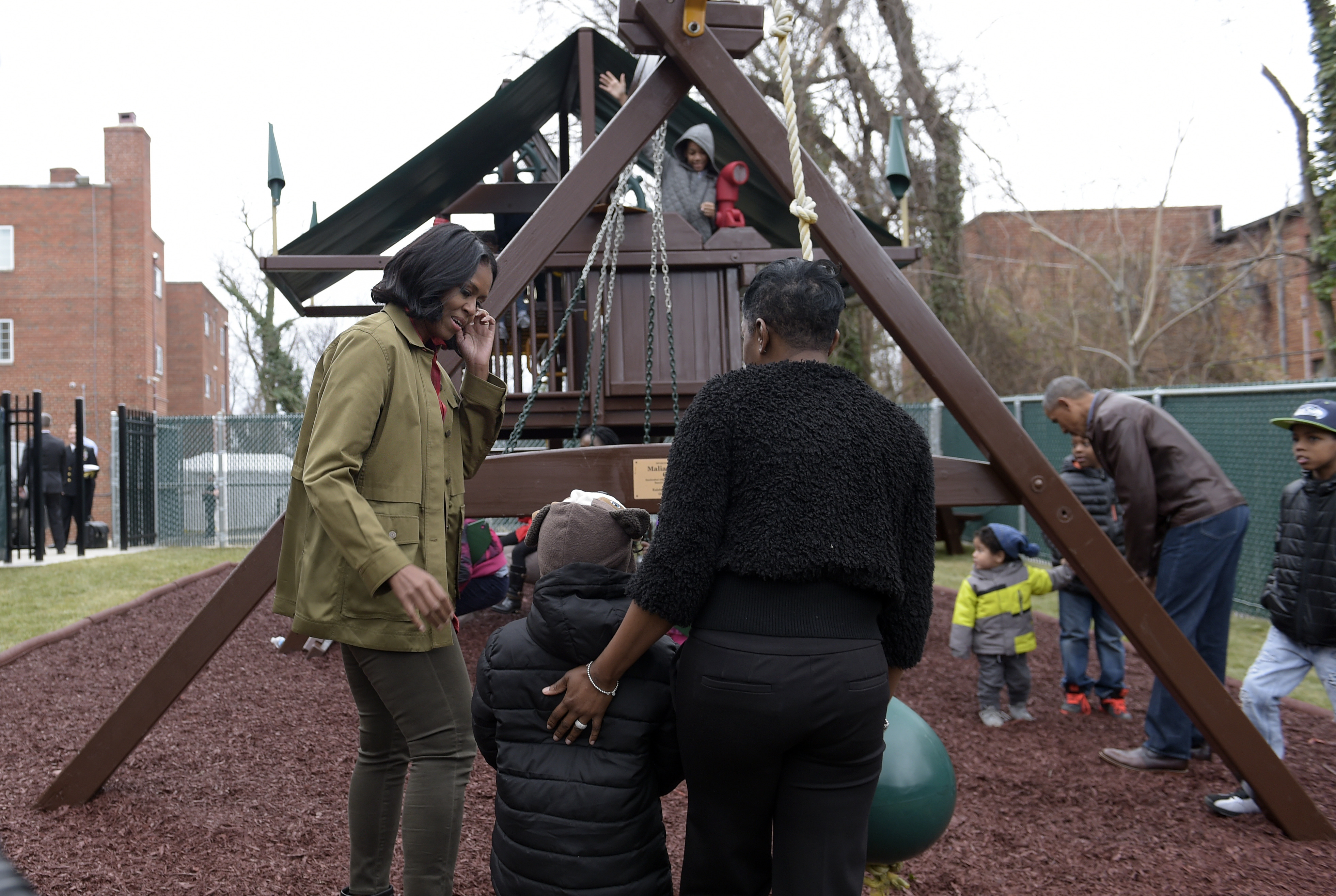 First lady Michelle Obama, left, talks with people as she and President Barack Obama visit the "Malia and Sasha's Castle," the playground that the Obamas donated to the Jobs Have Priority Naylor Road Family Shelter in Washington, Monday, Jan. 16, 2017. (AP Photo/Susan Walsh)