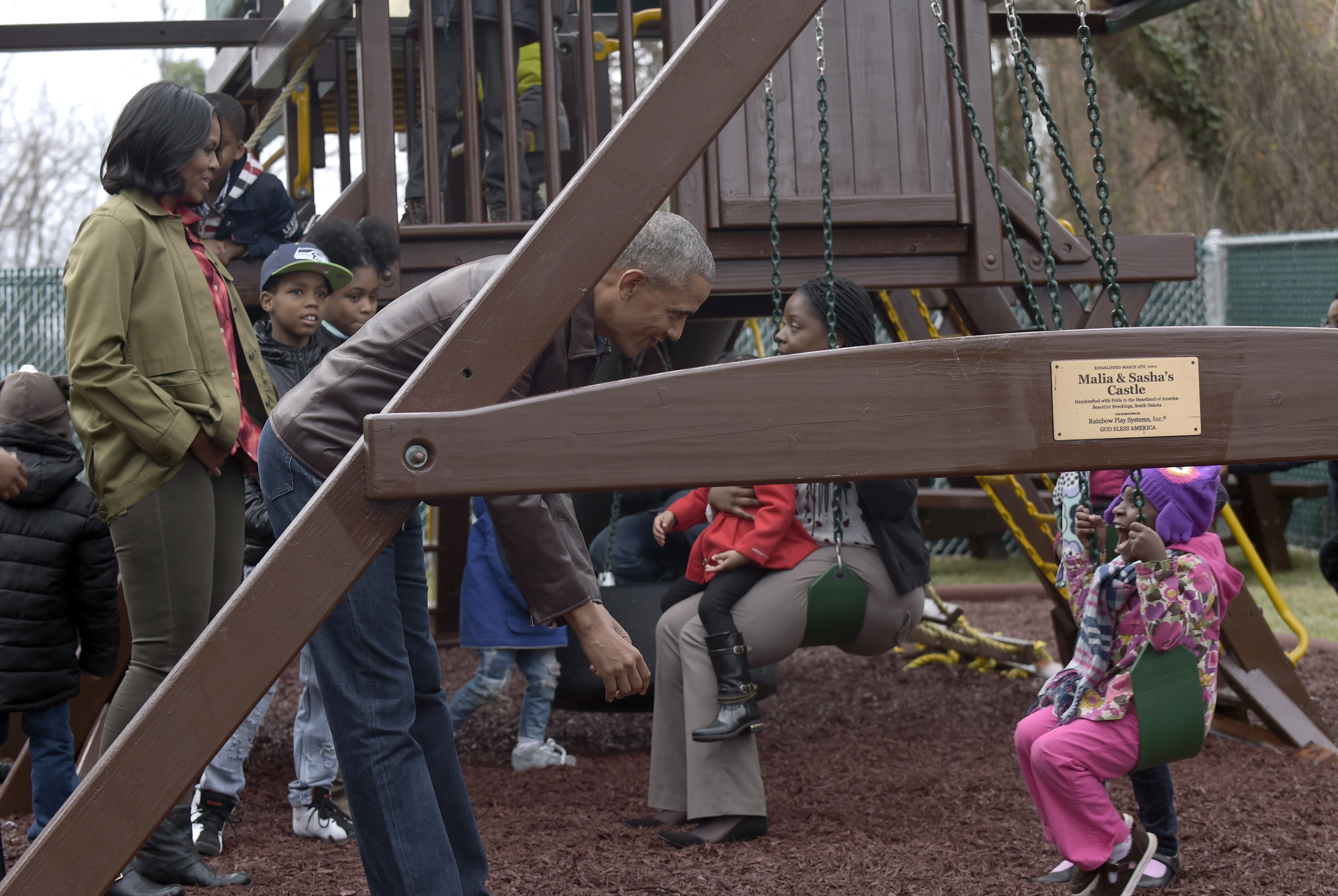 First lady Michelle Obama, left, and President Barack Obama visit the "Malia and Sasha's Castle," the playground that the Obamas donated to the Jobs Have Priority Naylor Road Family Shelter in Washington, Monday, Jan. 16, 2017. (AP Photo/Susan Walsh)