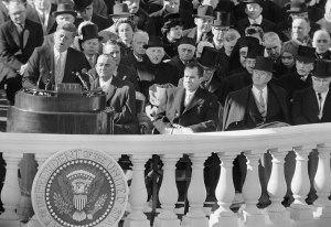 FILE - In this Jan. 20, 1961, black and white file photo,President John F. Kennedy gives his inaugural address at the Capitol in Washington after taking the oath of office. Listening in the front row, from left, are, incoming Vice President Lyndon Johnson, outgoing Vice president and Kennedy's defeated presidential opponent Richard M Nixon, Sen John Sparkman, D- Ala., and former President Harry Truman. (AP Photo, File)