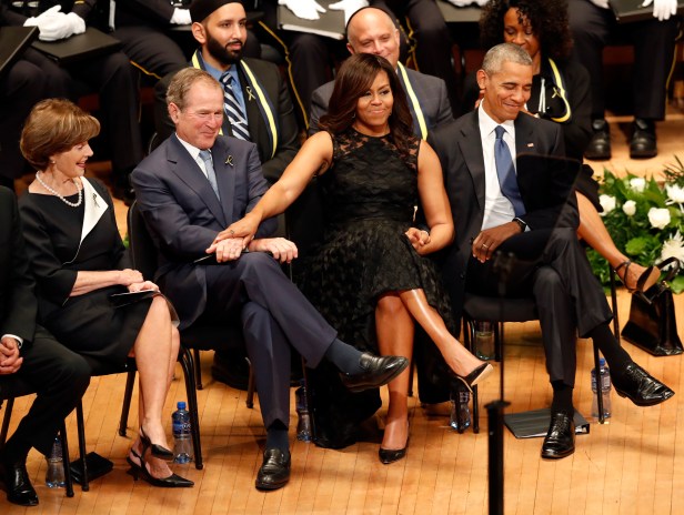 First lady Michelle Obama and President George W. Bush, flanked by President Barack Obama and former first lady Laura Bush, share a moment during a memorial service for five police officers were killed and several injured during a shooting in downtown Dallas last Thursday night, Tuesday, July 12, 2016, at the Morton H. Meyerson Symphony Center in Dallas. (AP Photo/Eric Gay)