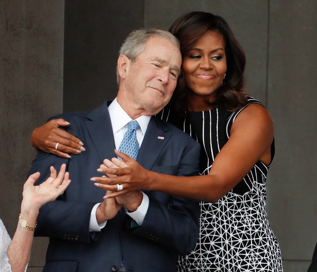 First lady Michelle Obama hugs former President George W. Bush during the dedication ceremony for the Smithsonian Museum of African American History and Culture on the National Mall in Washington, Saturday, Sept. 24, 2016. (AP Photo/Pablo Martinez Monsivais)