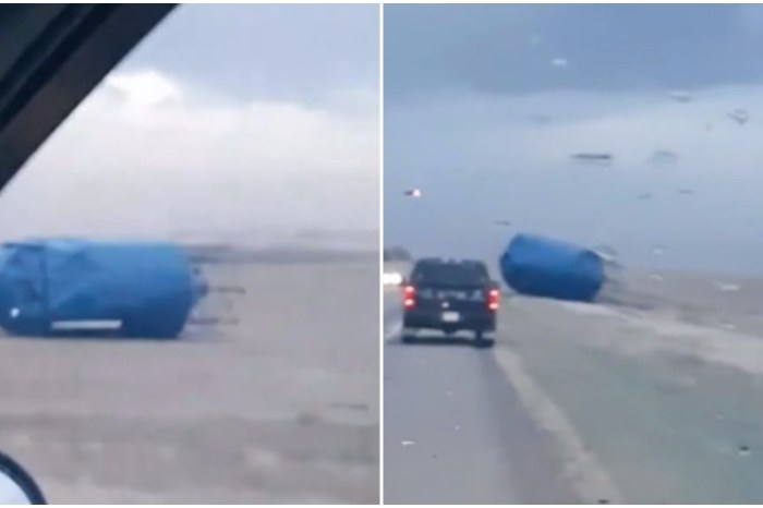 Howling winds hurl a silo into the road, feet from passing cars